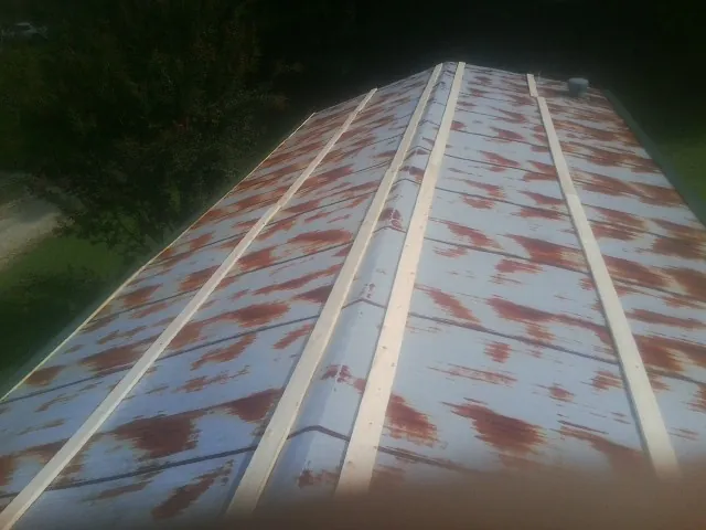Rusted metal roof panels with new wood purlins before replacement — Storm Damage Roof Repair in Glyndon by Roofing Brothers